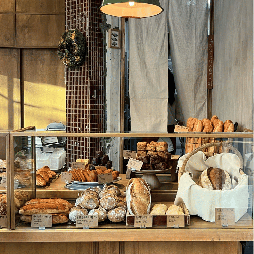 Panaderia de tendencia Vitrina de panadería con variedad de panes y pastelería.