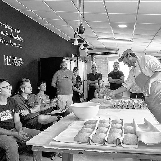 Javier Moreno en el obrador de Harinas La Encarnación Javier Moreno realiza un taller demostración a un grupo de panaderos artesanos en un obrador con mesas y utensilios de panaderia.